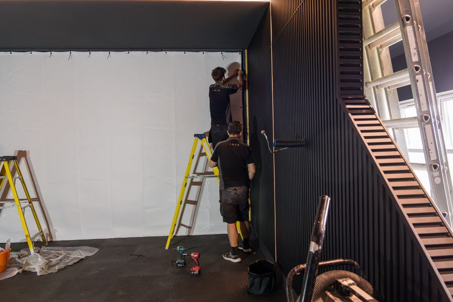 Engineers fitting out a golf simulator bay